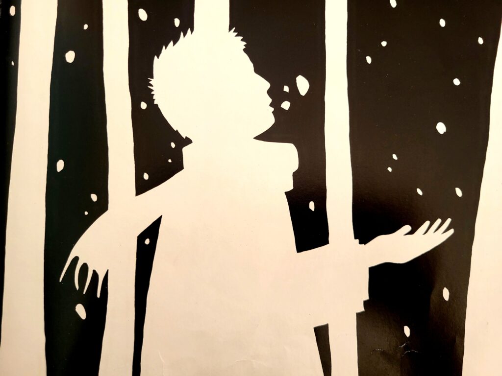 Le jeune garçon traverse la forêt sous la neige.